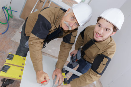 senior and young builder