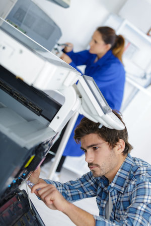 technician fixing broken photocopier machine