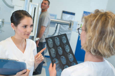 young female doctors looking at x-rayの写真素材