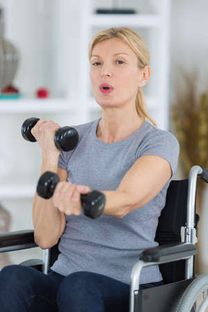 middle-age patient in lifting dumbbell in clinicの写真素材