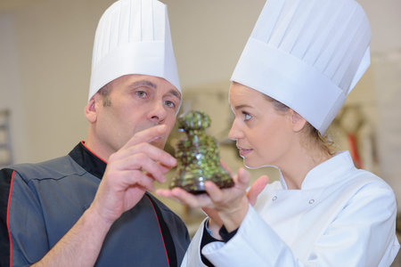 A pastry chef looking at a dessert
