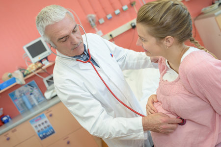 A doctor listening pulse of pregnant patient