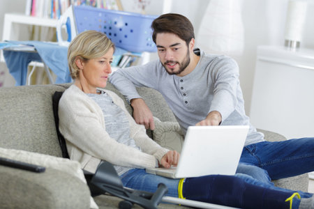 Young man helping injured woman to using computer