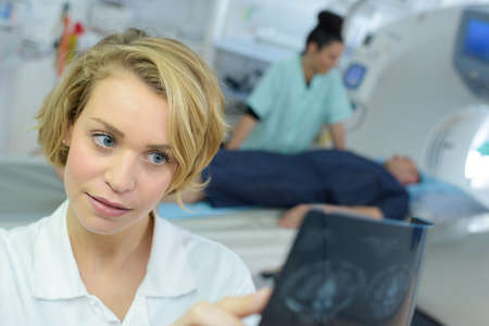female specialist checking brain tomography resultsの写真素材