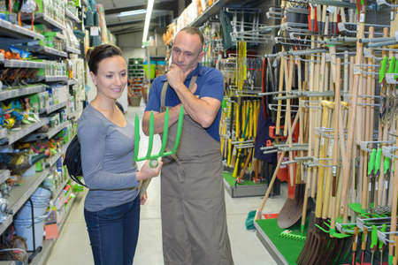 salesman helping custoler to buy a rake in supermarketの写真素材