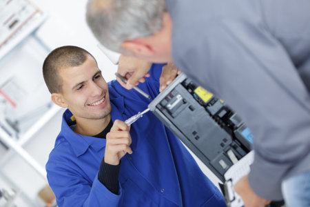 young apprentice engineer learning to fix computer