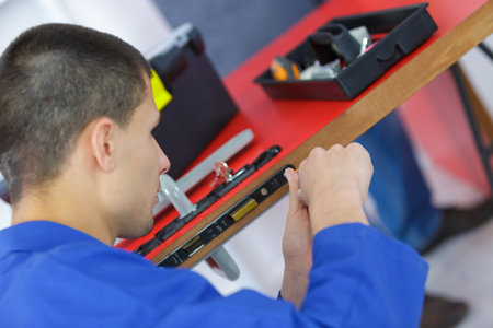young man fixing the door with screwdriver
