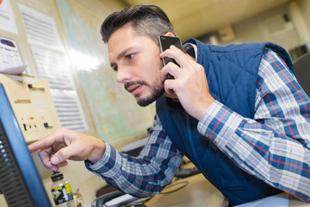 worker discussing some production line issues by phoneの写真素材
