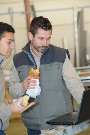 2 workers watching a movie on a laptop during lunchbreak