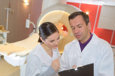 medical team discussing the report on clipboard at hospitalの写真素材