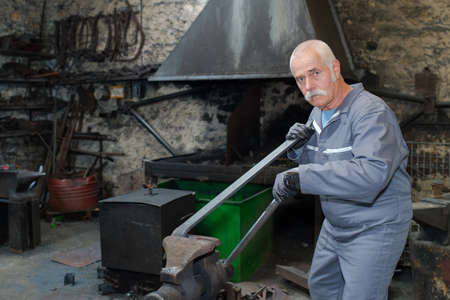 senior worker operates metalworking machineの写真素材