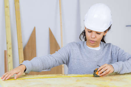 Female contractor using tape measureの写真素材