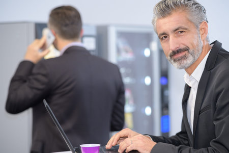 businessman having a cup of coffe while working on laptop