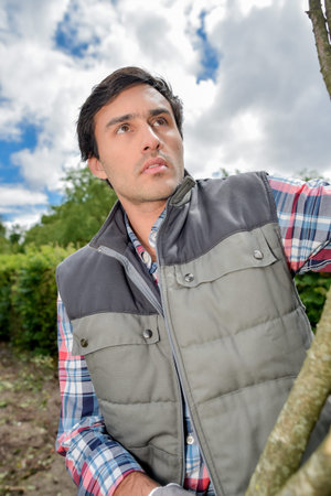 man working outdoors with branches