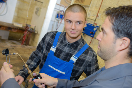 male apprentice learning to be welder