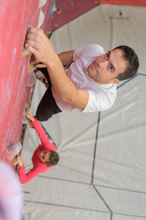 strong man and woman climbing up the wall