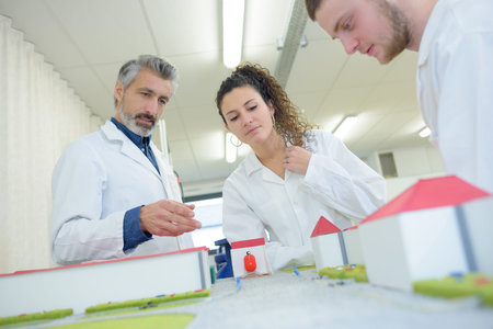 architecture students and teacher near scale model homes