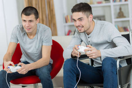 happy young brothers playing video gamesの写真素材