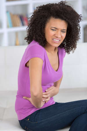 sick woman suffering from stomach acheの写真素材