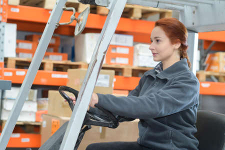 portrait of female fork lift truck driver in factoryの写真素材