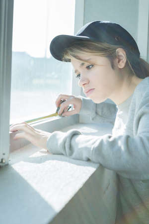 female worker using tape measure the window in construction siteの写真素材