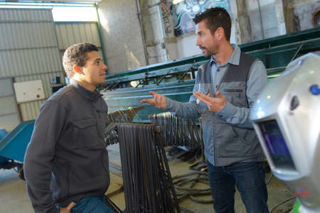 happy male worker showing something to coworkerの写真素材