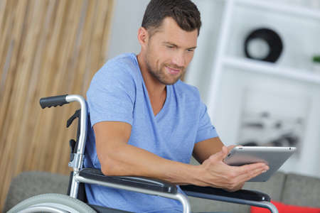 Disabled man enjoying using a tabletの写真素材
