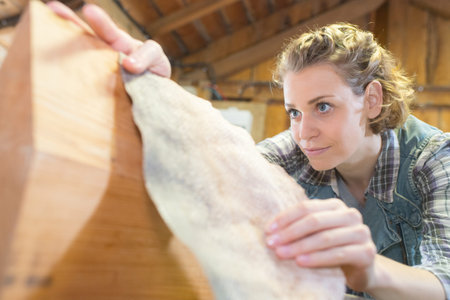 young woman cleans a wooden objetの写真素材
