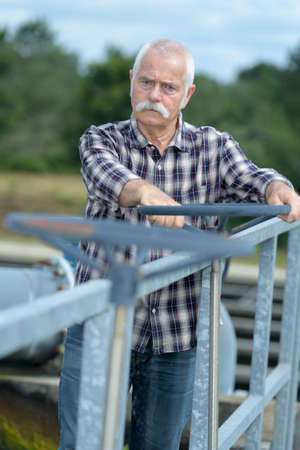 elderly worker at the factory with the pipe valveの写真素材