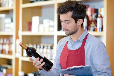 wine vendor reading the labelの写真素材