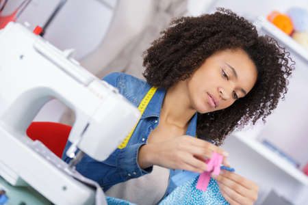 female dressmaker working with sewing machineの写真素材