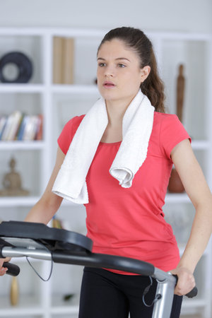 attractive fitness girl running on machine treadmill