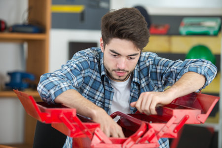 portrait of man unpacking his tool box at home