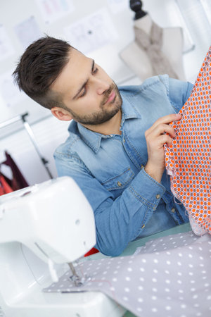 male dressmaker tailor fabric on table