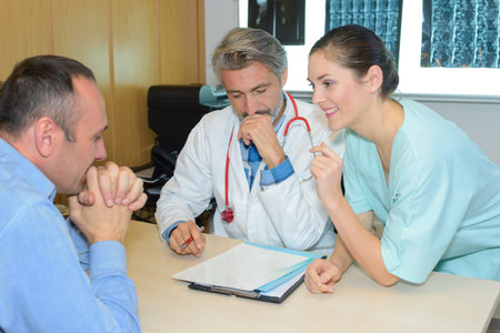 smiling female nurse with doctor and patient