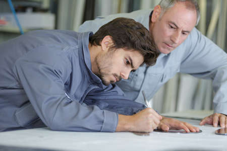 engineer is working on construction plan on his tableの写真素材