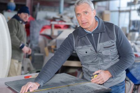 senior industrial worker in action on metal press machineの写真素材