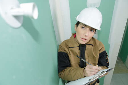 woman in helmet with clipboard in siteの写真素材