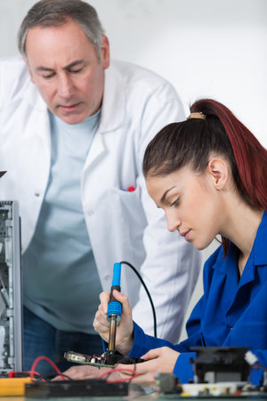 young woman student repairing electronics device