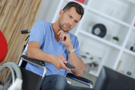 young handicapped man watching television in living room