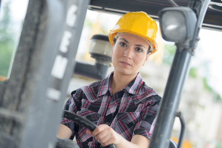 female fork lift truck driver in factoryの写真素材