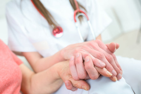 nurse holding hand of senior woman in wheel chairの写真素材