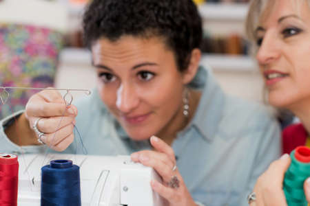 two dressmaker working on a sewing machineの写真素材