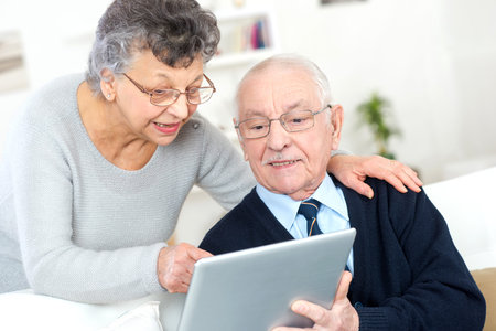 old couple looking camera with tablet pc in their hands