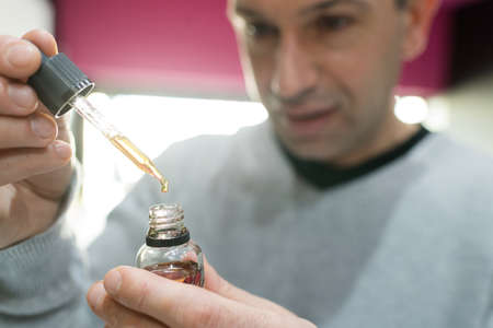 man filling an electronic cigarette with liquidの写真素材