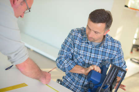 two male construction workers busy in building real estate houseの写真素材