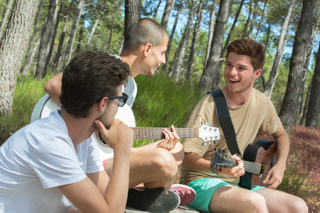 group of smiling tourists playing guitar