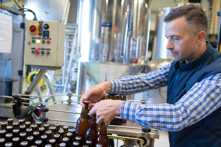 portrait of manufacturer examining beer in brewery