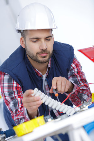 man at work testing wiring with a multi meter