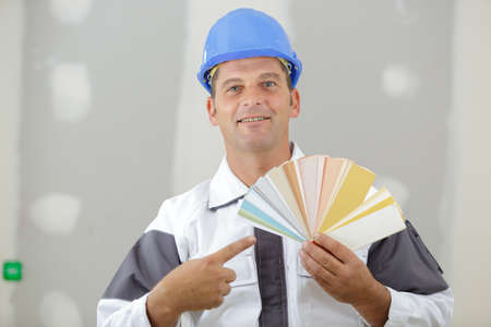 painter pointing at colours for painting jobの写真素材